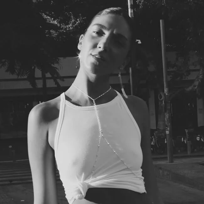 Black-and-white fashion portrait of a model in a white halter top