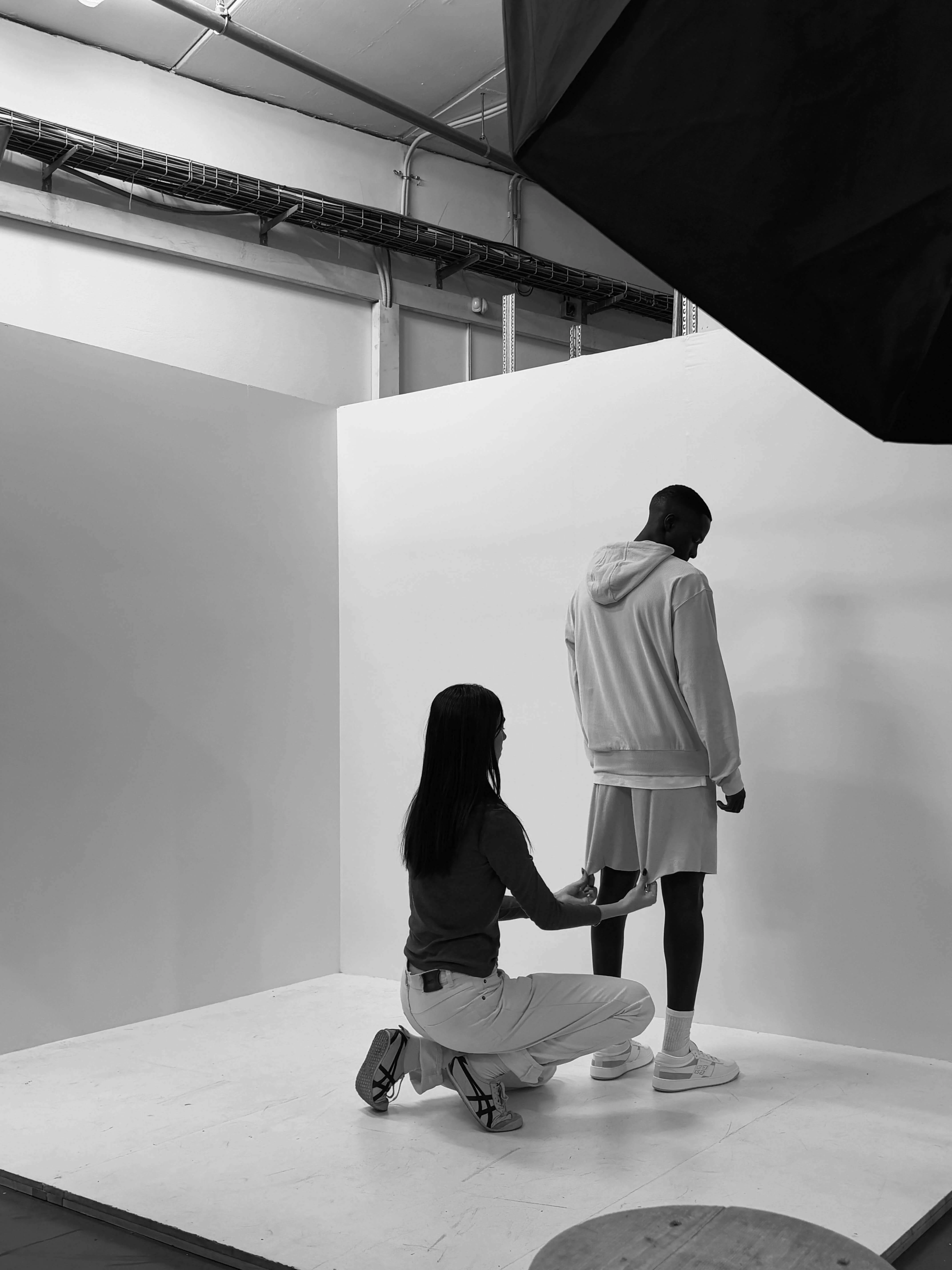 Minimalist white studio space with figures during a creative shoot